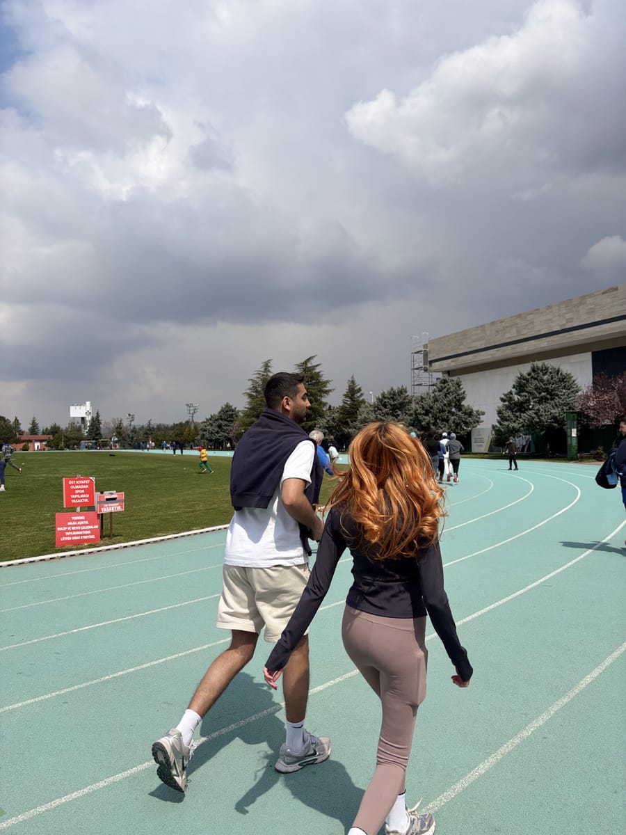 Atletizm pistinde omuz omuza yürüyen iki katılımcı, ücretsiz açık hava etkinliğinin soğuma turunda.